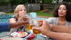 MS ZO Group of friends toasting drinks while dining together at table in backyard on summer evening Stock Footage