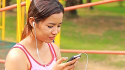 Asian girl listen music in playground Stock Footage
