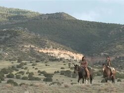 WS American Indian Native Couple Horse Back Riding in front of Spectacular New Mexico Red Rock Mountains / Santa Fe, New Mexico, United States  Stock Footage