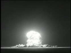 An atomic bomb explodes in the desert. News Clip