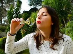 beautiful young woman with white dress blowing bubbles Stock Footage