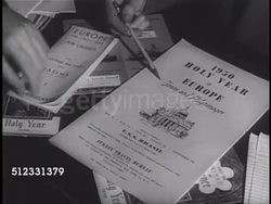 1950: DRAMATIZATION: Priest standing at counter w/ travel agent, Rome posters on wall BG. Travel agent hands showing brochures on desk. MS '1950-Holy Year' Brochures in display holder, male handing lifting out two folded information pamphlets. Instructional Video