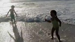 Children playing in ocean surf Stock Footage