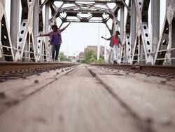 MS Young male and female couple walking and balancing on train track outside in urban area together having fun and smiling / Minneapolis, Minnesota, United States Stock Footage