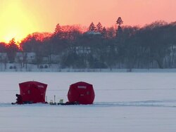 WS Sun rising over some early morning ice fishing Stock Footage