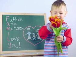 boy draws a card for parents on board Stock Footage