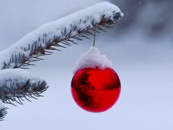 Snow gently falling on Christmas ornament hanging from tree Stock Footage