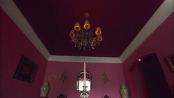 A chandelier hangs from the purple ceiling of a pink dining room at La Maison Hotel in Rio de Janeiro. Stock Footage