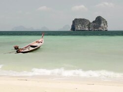 WS View of Long tail boat in Surf and Limestone rock in Sea, Marine National Park / Ko Hai, Krabi, Thailand Stock Footage