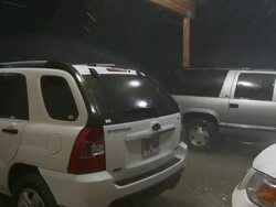 MS ZI Shot of vehicles under carport being pelted with rain and hail at night / Lemmon, South Dakota, United States Stock Footage