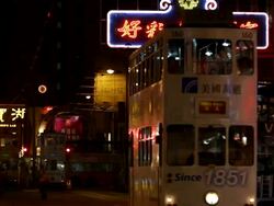 WS Trolley tram passing through street at night / Hong Kong, China Stock Footage