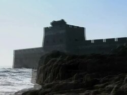 View of a tower that is part of the Great Wall of China, parts of which are covered in snow.   Stock Footage