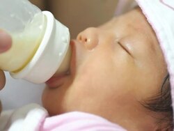 Baby infant suckling milk from bottle Stock Footage