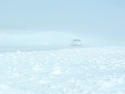 Winter Blizzard with Blowing Snow Across Highway and Vehicles Stock Footage