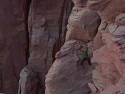 WS PAN Climber makes his way to top of large rock climb and climber in green jacket with red rocks all around  / Zion, UT, USA Stock Footage