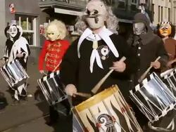 MS Shot of people with mask and dressing up playing drums at celebrating Basler Fasnacht (Basel Carnival) on street / Basel, Switzerland Stock Footage