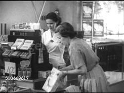 1952: STATE OF THE NATION: AMERICAN ECONOMY: Woman placing food items on grocery store checkout counter (meat, Tide, box, can) female cashier behind register, CU Cash register total of $14.90, woman repeating price, shaking head, handing cashier bills Instructional Video