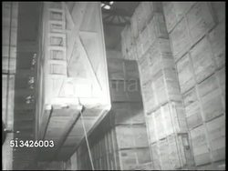 1940s: UNITED STATES NAVY PORT: INT VS Large wooden cargo being moved by crane in U.S. Navy port warehouse, storage, men stenciling destinations code names onto crates, 'Cactus, Cheekstrap, Jerk.' WWII, World War II, Pacific Front, islands, yard Instructional Video