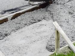 MS Shot of Workmen spreading and leveling concrete being poured for sidewalk / Valparaiso, Indiana, United States Stock Footage