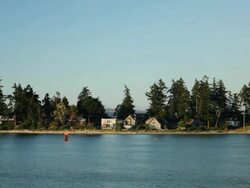 Point of view, ferry glides past houses on Bainbridge Island. Stock Footage