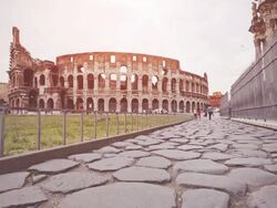 Roman road with cobblestones and the Coliseum, in Rome Stock Footage