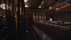 A bartender tidies a bar while a hotel restaurant awaits patrons. Stock Footage