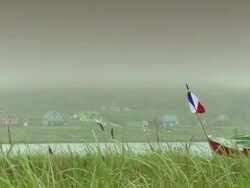 Flag of Acadia on a boat with a little village in the background Stock Footage