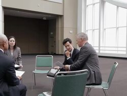  PAN Business associates meeting and discussing items on digital tablet / Seattle, Washington, United States Stock Footage