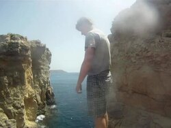 POV of a young man jumping off a cliff and doing a backflip in Malta. - Model Released - HD Stock Footage