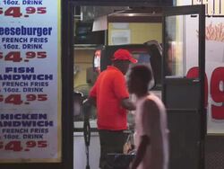 An employee stuffs a hot dog bun at a fast food place in the city. Stock Footage