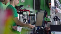 Cashier hands customer receipt and spikes receipt on spindle at sales counter Stock Footage