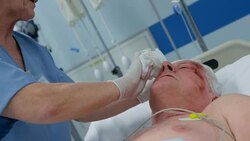 Nurse bathing senior man lying in intensive care unit Stock Footage