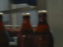 CU PAN Shot of brown glass beer bottles moving along conveyor / Wau, Western Bahr el Ghazal, Sudan  Stock Footage