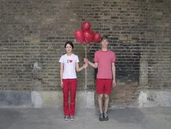 Young couple let go of a of heart shaped helium balloons then look sad Stock Footage