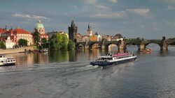 Boats on the Vltava River pass near the Charles Bridge. Stock Footage
