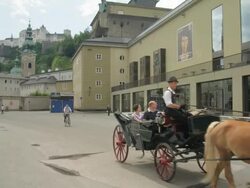 WS horse drawn carriage in front of main entrance to the Festspielhaus (festival hall), Hohensalzburg Castle in background Stock Footage