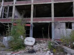 Exterior dolly view of abandoned auto assembly plant Stock Footage