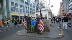 Tourists at Check point Charlie with actors dressed as American soldiers Stock Footage