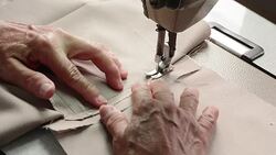 Seamstress using Sewing Machine hands focus Stock Footage