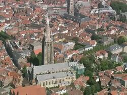 MS AERIAL PAN ZI View of Onze lieve Vrouekerk (tallest Belgian spire) and traffic moving by canal / Flanders, Belgium Stock Footage