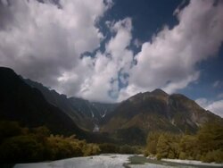T/L clouds passing over autumn brown valley with river in foreground, Kamikochi, Japan Stock Footage