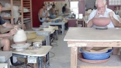 pottery studio shared by hobby potters as the artists are sculpting and painting various vessels Stock Footage