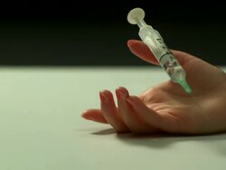 High speed Young lady's hand falls and drops syringe, split background Stock Footage