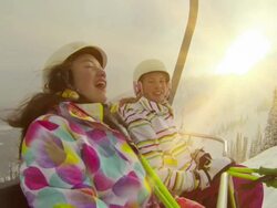 Two young girls riding chair lift at ski hill Stock Footage