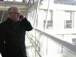 MS Middle aged businessman talking on cell phone inside office building during day / Minneapolis, Minnesota, United States Stock Footage