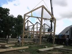 WS ZO Carpenters and forklift operator slowly moving part of structure into place during framing of an energy efficient post / Grass Lake, Michigan, USA  Stock Footage