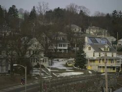Long Shot static - Light traffic passes a neighborhood in Vermont. / Vermont, USA Stock Footage