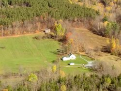 MS AERIAL DS ZI ZO View of Homer Noble Farm and Robert Frost Cabin surrounded by trees / Vermont, United States Stock Footage