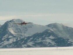 WS TS of DC-3 plane coming in to land on pack ice with snowy mountains / Union Glacier, Heritage Range, Ellsworth Mountains, Antarctica  Stock Footage