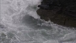 Ocean waves crash against rocky cliffs. Stock Footage